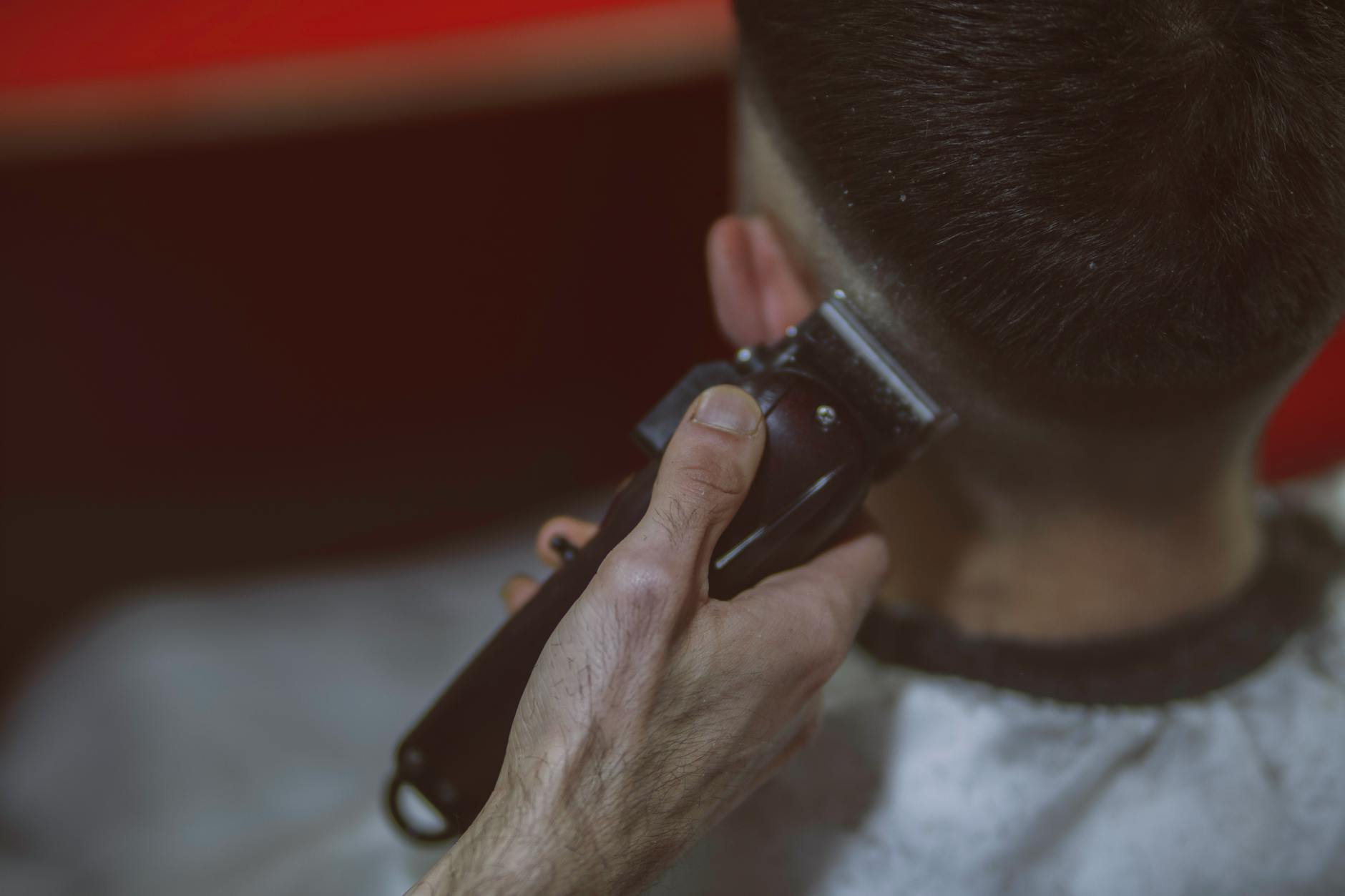 Barber apprentice providing a client service in a professional shop